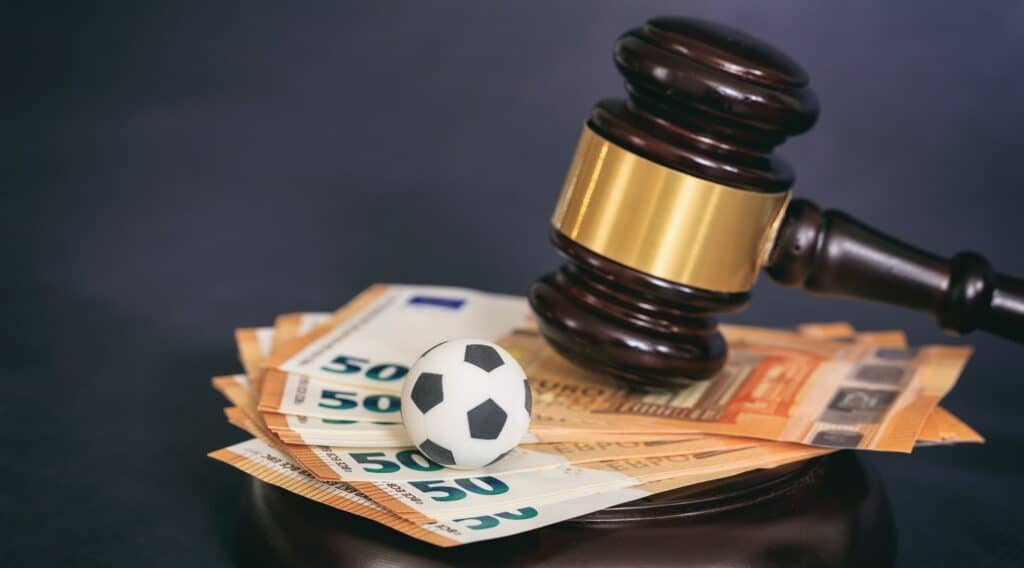 Law gavel, soccer ball and euros on black background